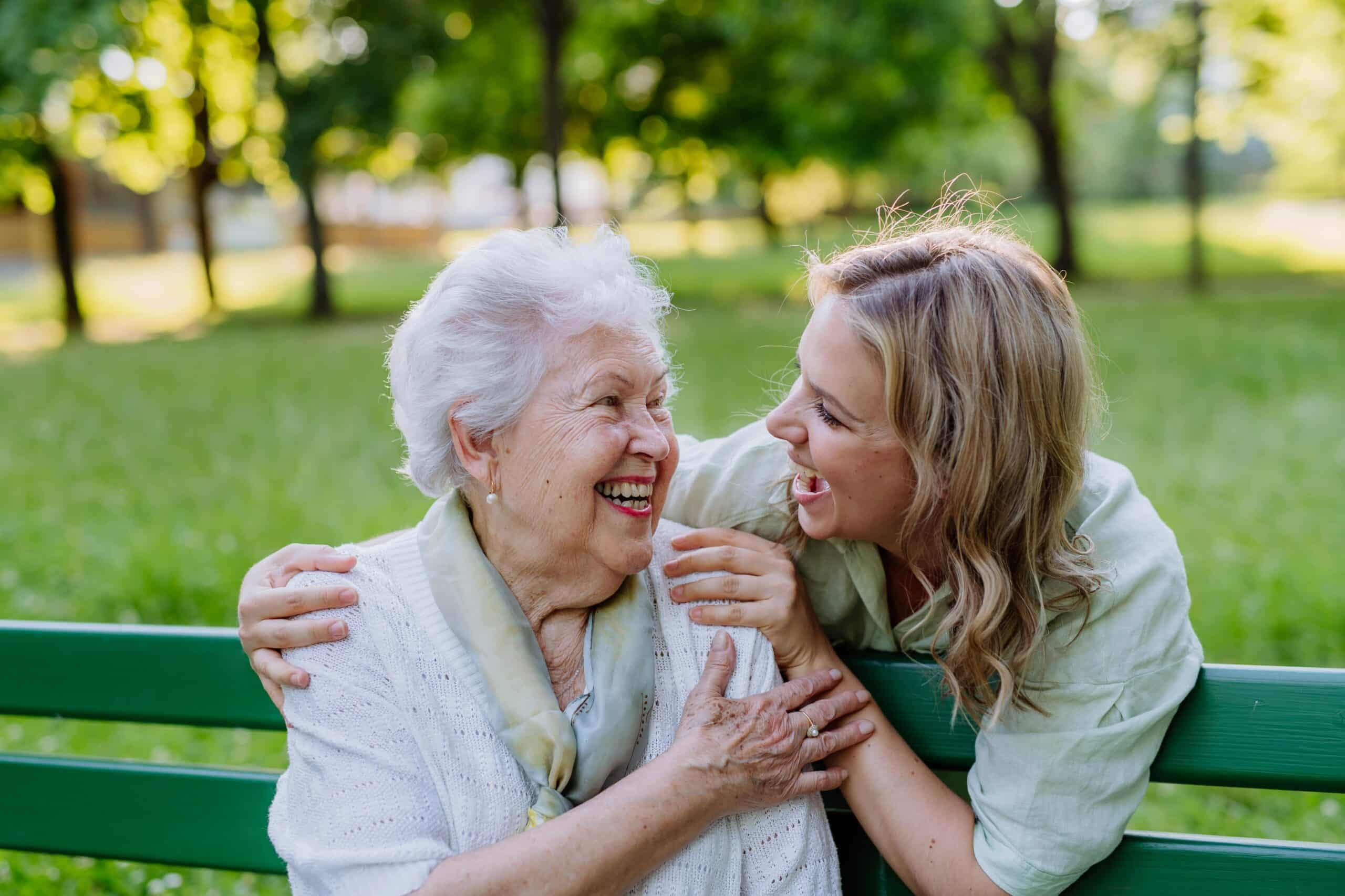 Senior woman and young woman in park, smiling