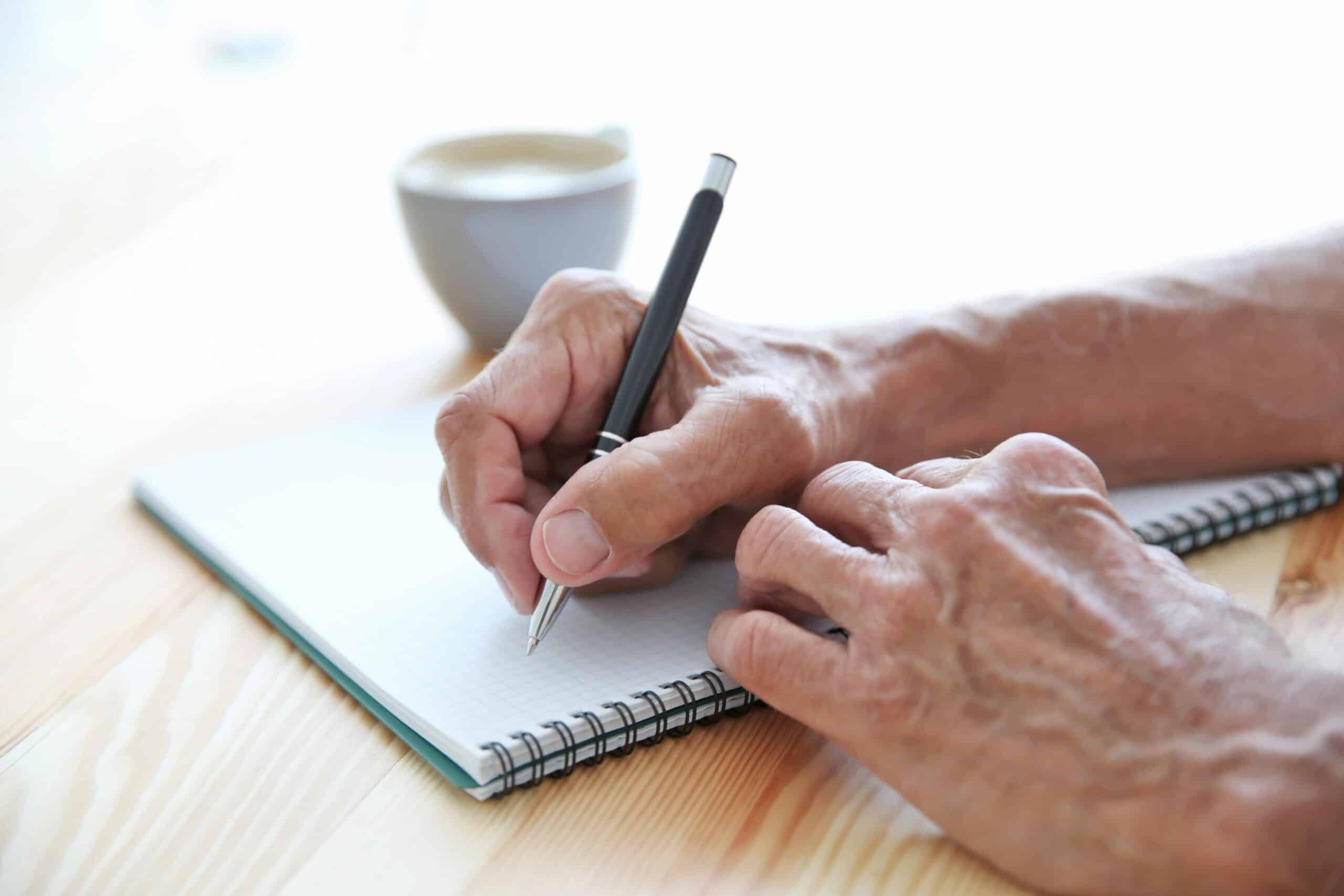 Close-up of senior hand writing